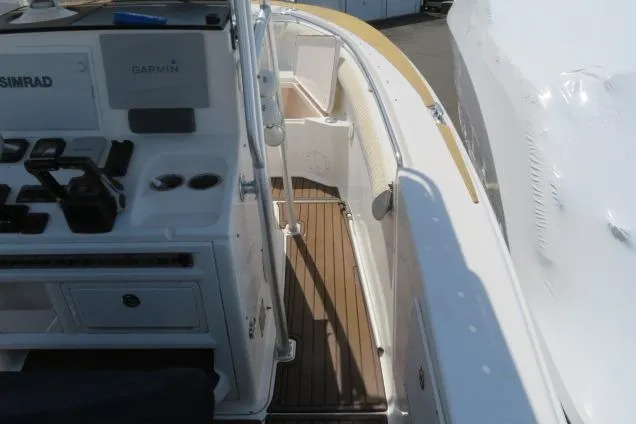Slide: The Image of 2006 Sea Hunt Triton 260 boat deck with navigation equipment and wooden flooring. - 20