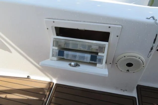 Slide: The Image of Storage compartment on 2006 Sea Hunt Triton 260 boat with speaker and wooden flooring. - 22
