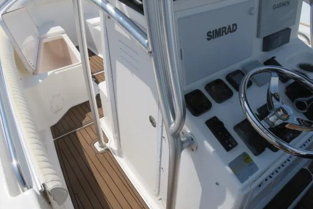 Slide: The Image of 2006 Sea Hunt Triton 260 boat console with Simrad and Garmin electronics, featuring a sleek steering wheel. - 24