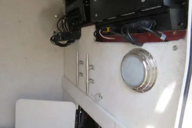 Slide: The Image of Interior view of a 2006 Sea Hunt Triton 260 boat, featuring electronic equipment and a speaker. - 27