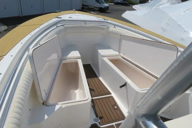 Slide: The Image of 2006 Sea Hunt Triton 260 boat interior with open storage compartments and cushioned seating. - 29