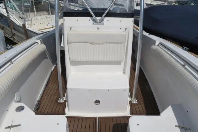 Slide: The Image of 2006 Sea Hunt Triton 260 boat interior with white seating and wood flooring. - 30