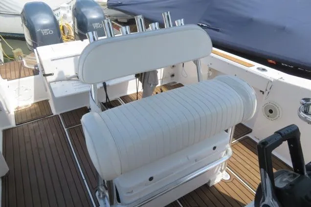 Slide: The Image of 2006 Sea Hunt Triton 260 boat interior with white seating and twin engines. - 31