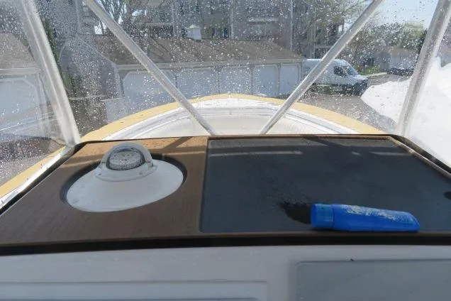 Slide: The Image of 2006 Sea Hunt Triton 260 dashboard with compass and sunscreen tube. - 34