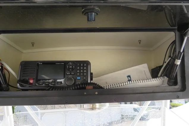 Slide: The Image of 2006 Sea Hunt Triton 260 boat dashboard with radio equipment and documents. - 35