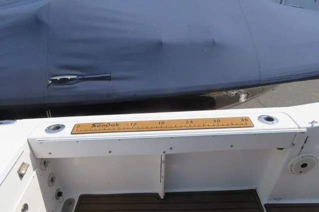 Slide: The Image of 2006 Sea Hunt Triton 260 boat deck with ruler and covered seating area. - 8