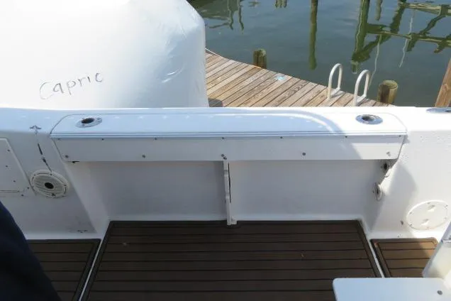 Slide: The Image of 2006 Sea Hunt Triton 260 boat deck with wooden flooring and dock view. - 9