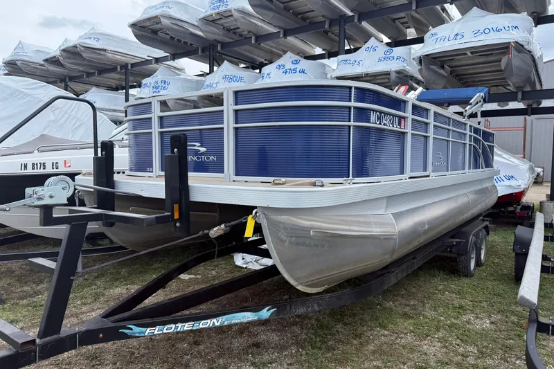 The Image of 2020 Bennington SX22 pontoon boat on trailer, surrounded by covered boats. - 1