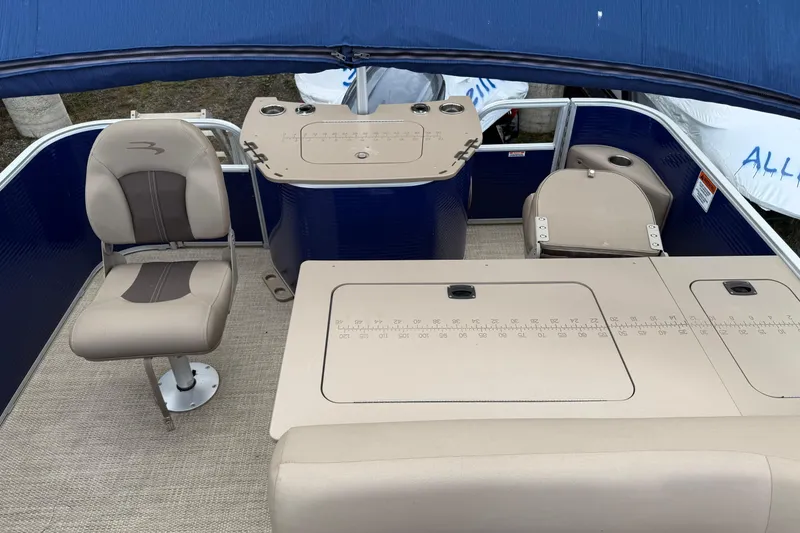 Slide: The Image of 2020 Bennington SX22 boat interior with seating and control panel under blue canopy. - 6