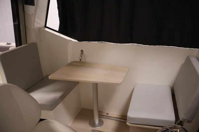 Slide: The Image of 2026 Bayliner Trophy T25 Pilothouse interior with seating and table. - 55