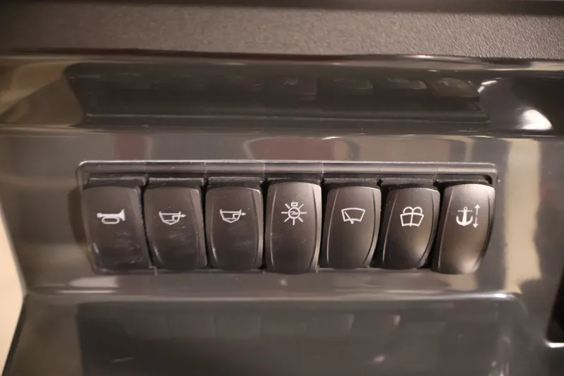 Slide: The Image of Control panel switches on a 2026 Bayliner Trophy T25 Pilothouse boat dashboard. - 44