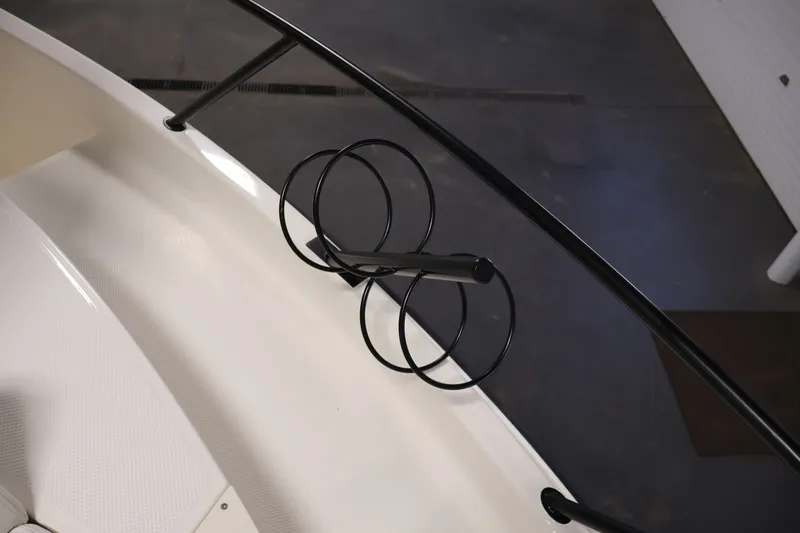 Slide: The Image of 2026 Bayliner Trophy T25 Pilothouse boat detail with black railing and rod holders. - 36