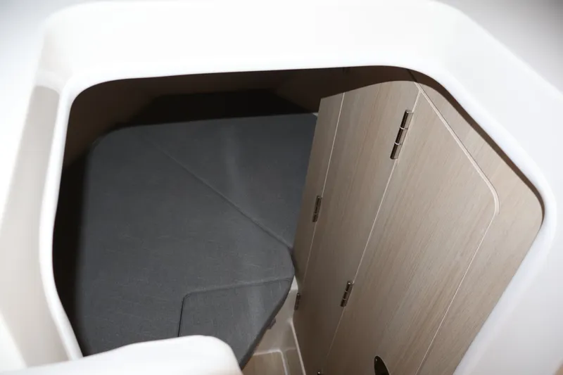 Slide: The Image of 2026 Bayliner Trophy T25 Pilothouse cabin interior with wooden door and cozy sleeping area. - 60