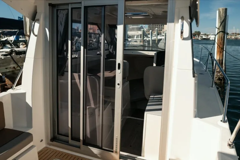 Slide: The Image of 2026 Bayliner Trophy T25 Pilothouse with sliding glass doors at marina. - 4