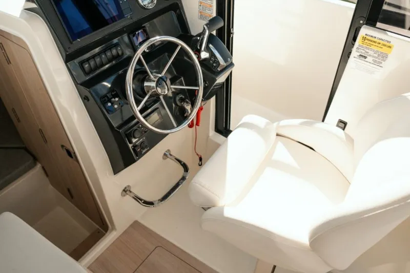 Slide: The Image of 2026 Bayliner Trophy T25 Pilothouse helm with steering wheel and captain's chair. - 5