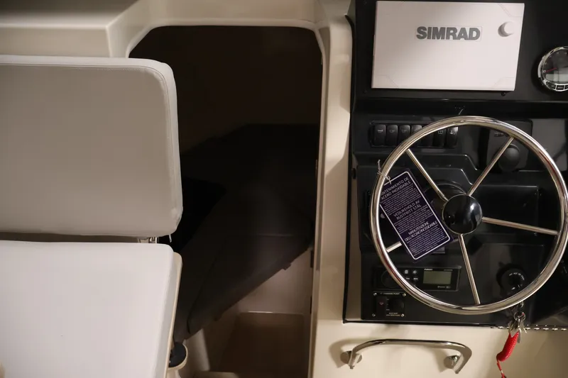 Slide: The Image of Interior of 2026 Bayliner Trophy T25 Pilothouse with steering wheel and Simrad display. - 59