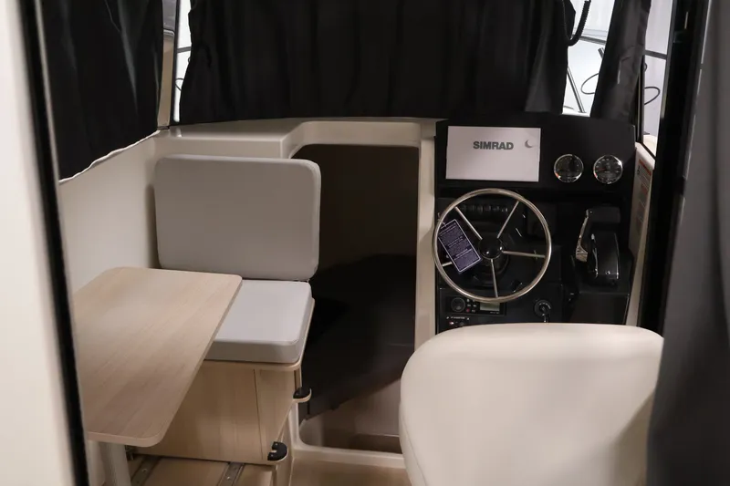 Slide: The Image of Interior of 2026 Bayliner Trophy T25 Pilothouse with steering wheel and seating area. - 39