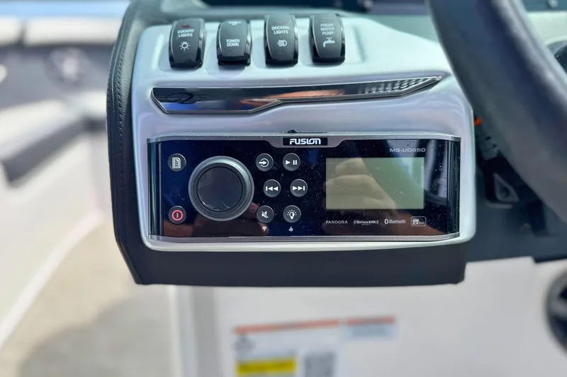 Slide: The Image of Control panel of a 2019 Regal 21 OBX boat featuring a Fusion MS-UD650 stereo system. - 26