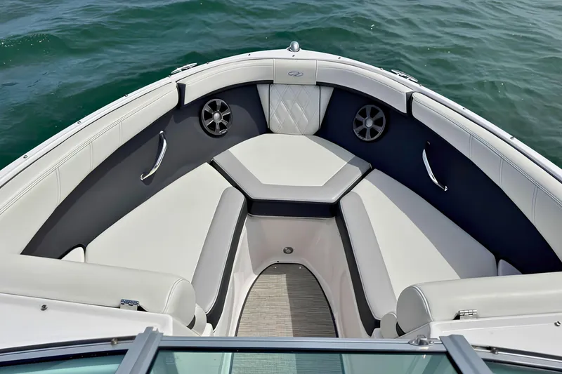 Slide: The Image of 2019 Regal 21 OBX boat interior with cushioned seating and speakers on calm water. - 29