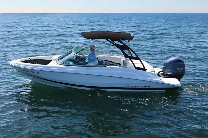 Slide: The Image of 2019 Regal 21 OBX boat cruising on open water, featuring a sleek design and Yamaha outboard motor. - 4