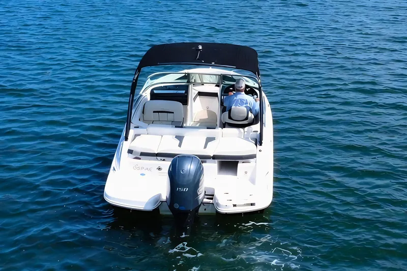Slide: The Image of 2019 Regal 21 OBX boat cruising on open water with a person at the helm. - 7
