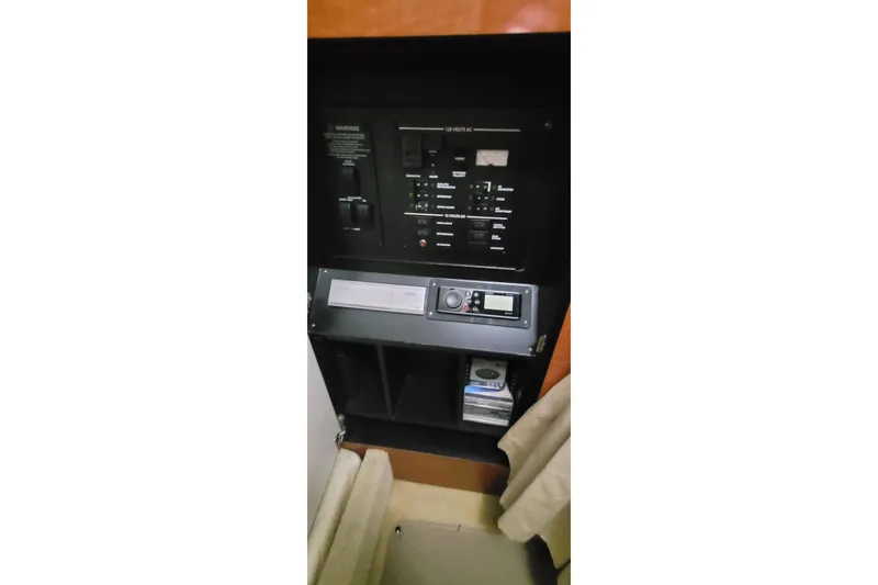 Slide: The Image of Control panel inside 2004 Sea Ray Sundancer 280 boat cabin, featuring electrical switches and stereo system. - 22