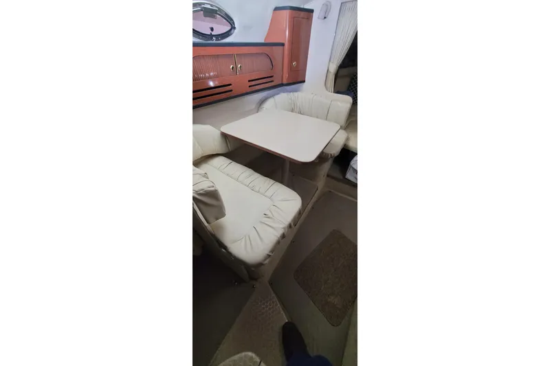 Slide: The Image of Interior of 2004 Sea Ray Sundancer 280 with cozy seating and wooden cabinetry. - 25
