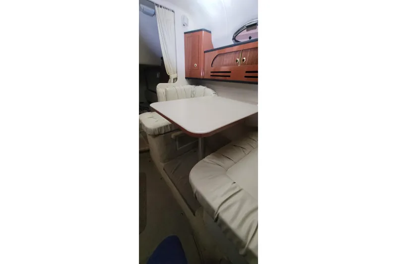 Slide: The Image of Interior of 2004 Sea Ray Sundancer 280 with dining area and cushioned seating. - 26
