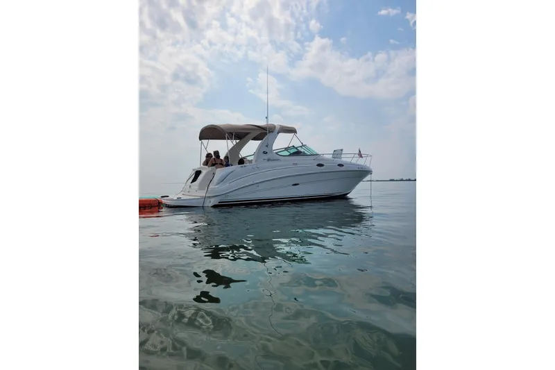 Slide: The Image of 2004 Searay 280 Sundancer boat on calm water under a partly cloudy sky. - 3