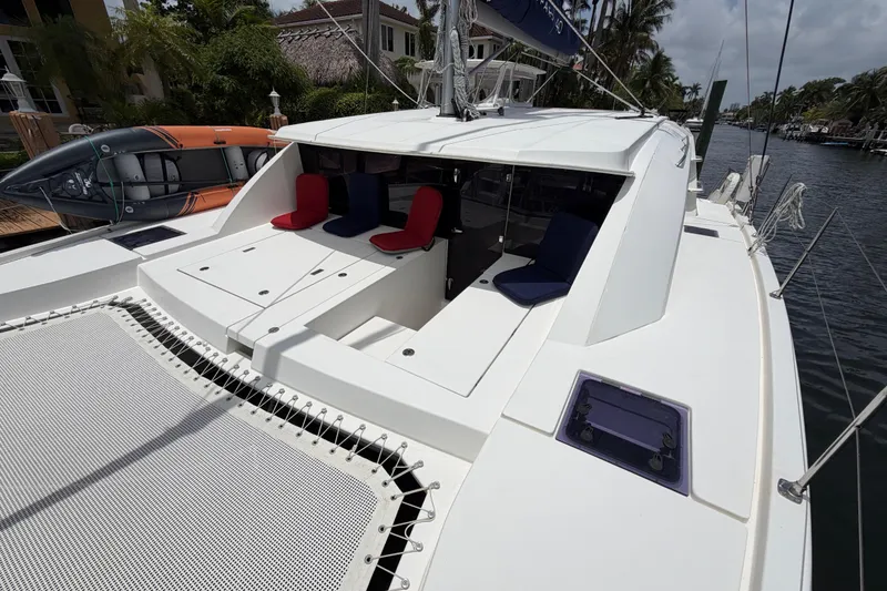Slide: The Image of 2020 Leopard 40 catamaran with seating area and trampoline deck, docked by palm trees. - 14