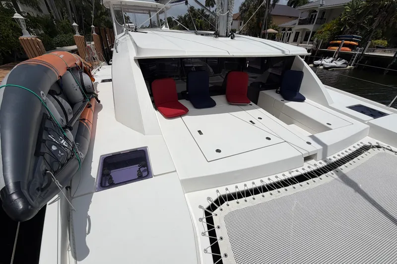 Slide: The Image of 2020 Leopard 40 catamaran deck with seating and inflatable boat, docked in a marina. - 16