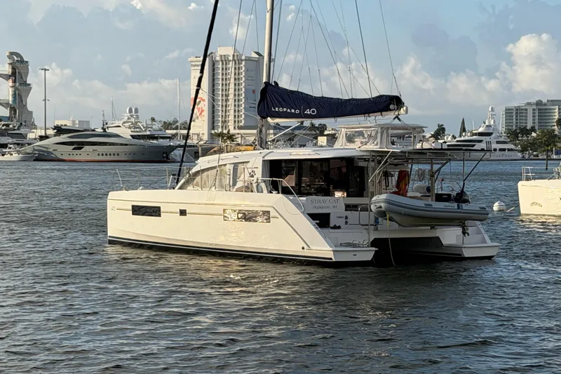 Slide: The Image of 2020 Leopard 40 catamaran docked in a marina with cityscape background. - 2