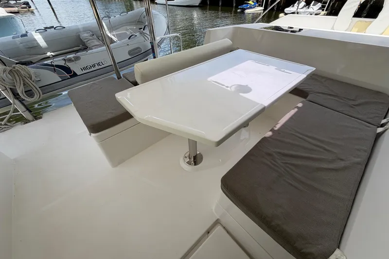 Slide: The Image of Outdoor seating area on a 2020 Leopard 40 catamaran with a white table and cushioned benches. - 23