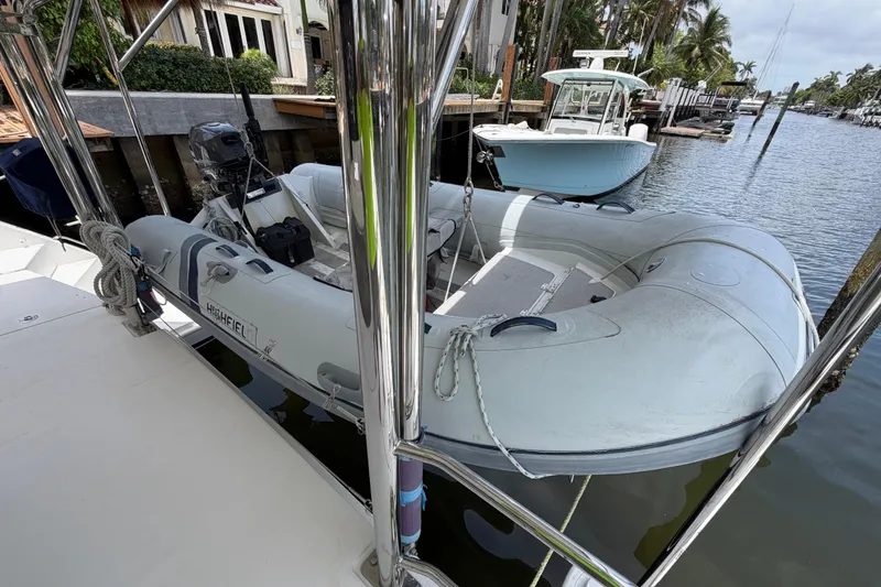 Slide: The Image of Inflatable dinghy docked beside a Leopard 40 catamaran, 2020 model, in a marina setting. - 27