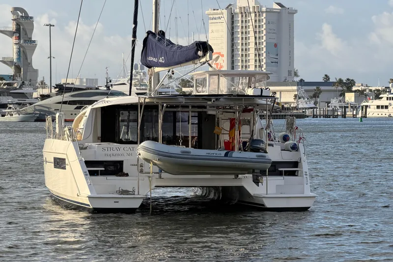 Slide: The Image of Leopard 40 catamaran, 2020 model, docked with dinghy, cityscape in background. - 3
