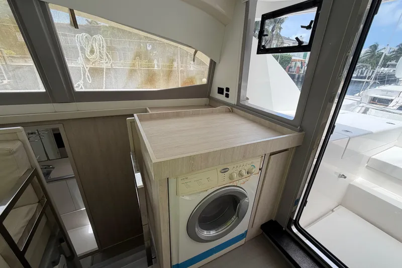 Slide: The Image of Interior of a 2020 Leopard 40 yacht featuring a compact laundry area with a washing machine. - 48