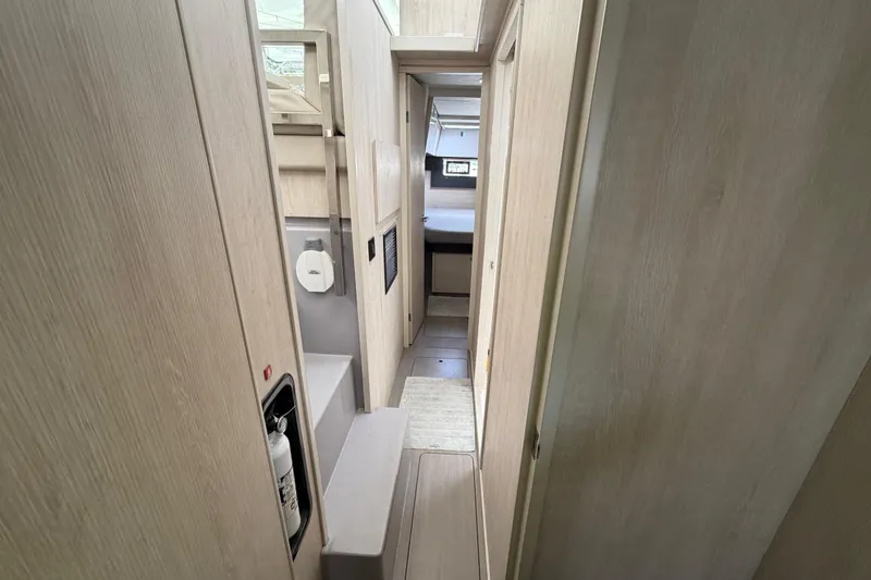 Slide: The Image of Narrow hallway inside 2020 Leopard 40 catamaran, featuring light wood paneling and compact design. - 61