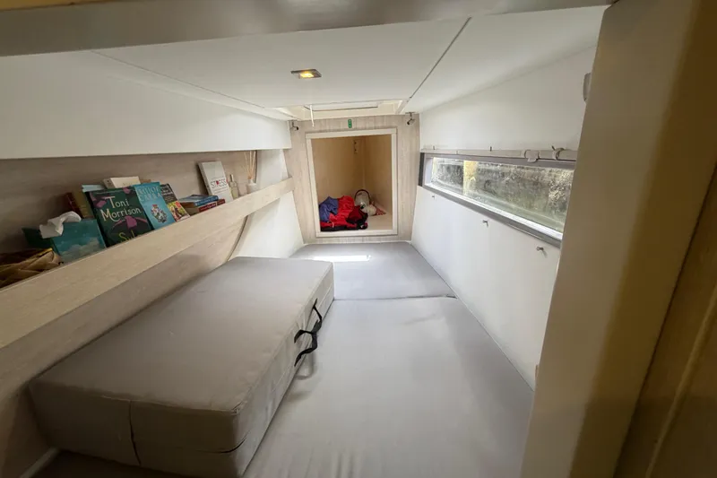 Slide: The Image of Cozy cabin interior of 2020 Leopard 40 catamaran with books and window view. - 63