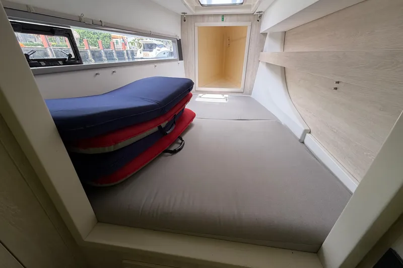 Slide: The Image of Interior cabin of a 2020 Leopard 40 catamaran with stacked cushions and window view. - 64