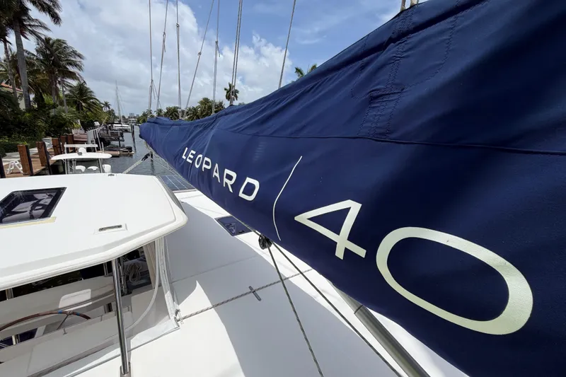 Slide: The Image of 2020 Leopard 40 catamaran with blue sail cover docked near palm trees. - 71