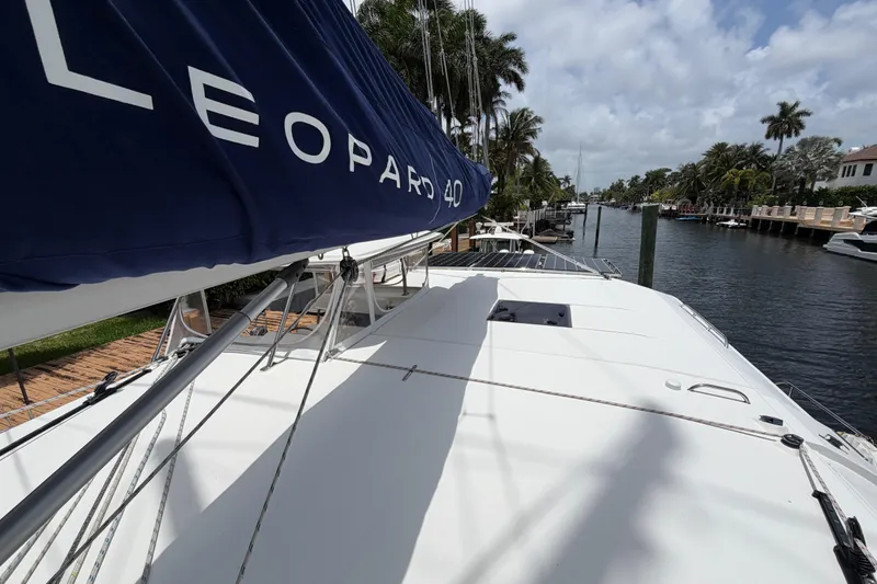 Slide: The Image of 2020 Leopard 40 catamaran docked by a scenic canal with palm trees. - 74