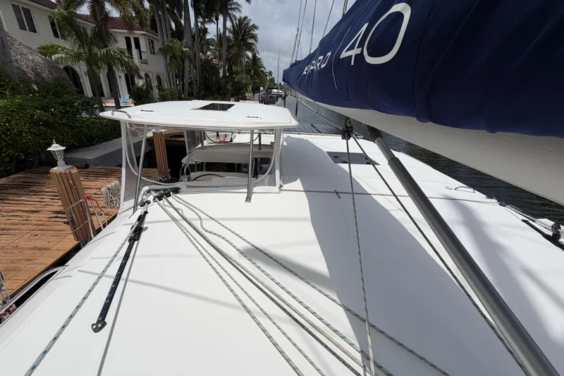 Slide: The Image of 2020 Leopard 40 catamaran docked near palm trees and waterfront homes. - 75
