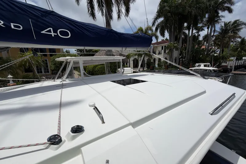 Slide: The Image of 2020 Leopard 40 catamaran docked, surrounded by palm trees and waterfront homes. - 76