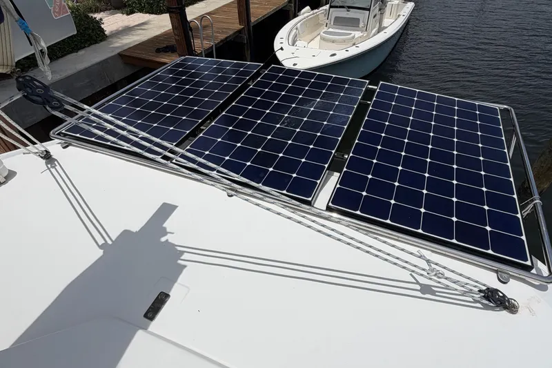 Slide: The Image of Solar panels on a 2020 Leopard 40 catamaran docked near a small boat. - 77