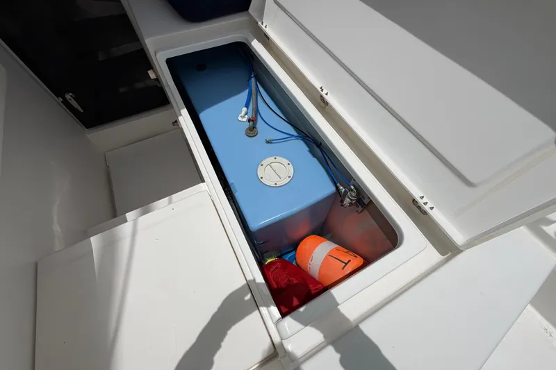 Slide: The Image of Storage compartment on a 2020 Leopard 40 boat with a blue tank and safety equipment. - 81