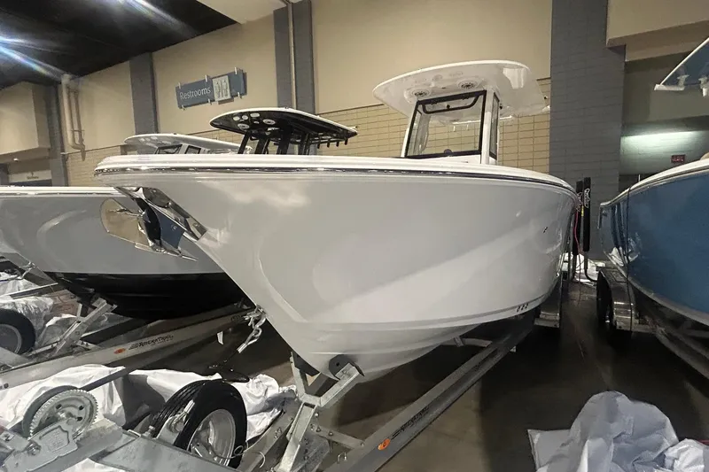 The Image of 2026 Sportsman Heritage 231 Center Console boat displayed indoors on a trailer. - 1