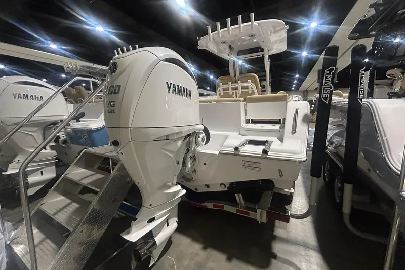 Slide: The Image of 2026 Sportsman Heritage 231 Center Console boat with Yamaha engine displayed indoors. - 5