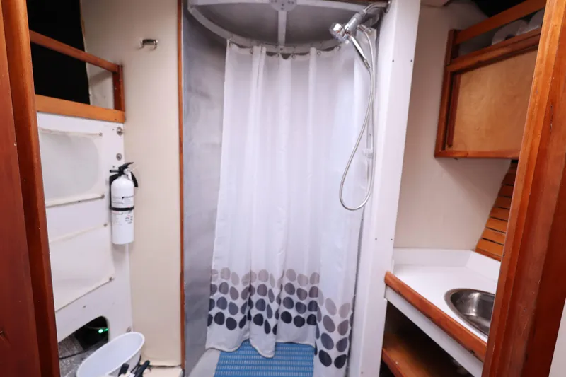 Slide: The Image of Compact bathroom with shower, sink, and fire extinguisher in a 1998 Limited Edition Hike Metal. - 11