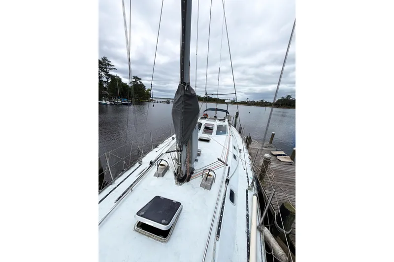 Slide: The Image of Limited Edition 1998 Hike Metal sailboat docked on a calm river under cloudy skies. - 17
