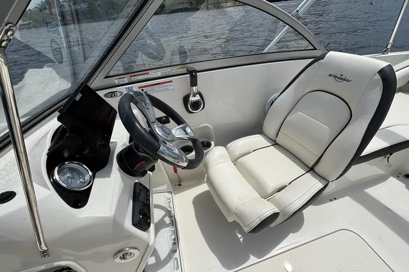 Slide: The Image of 2020 Stingray 191 DC boat interior with steering wheel and white captain's chair. - 11